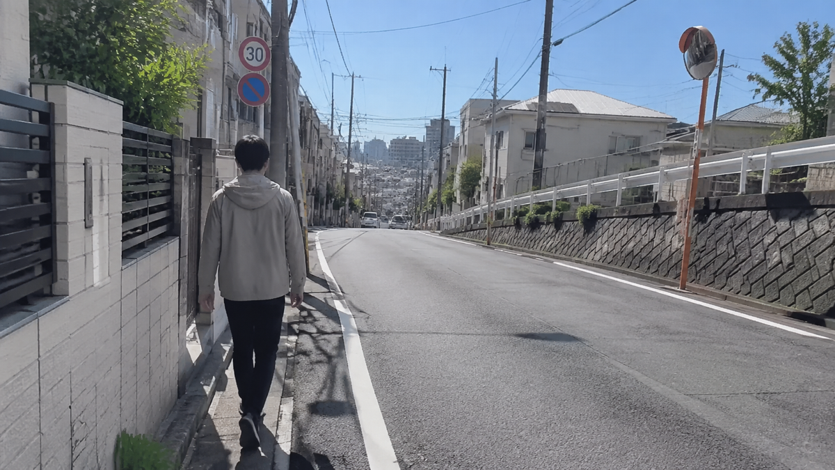 晴れた日に徒歩で坂道の高低差を確認するイメージ